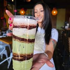Girl holding layered green drink